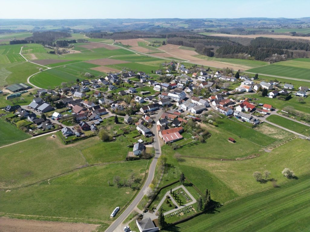 Luftaufnahme des Dorfes Oberöfflingen umgeben von Feldern und Wiesen. Grüne Landschaft im Hintergrund.